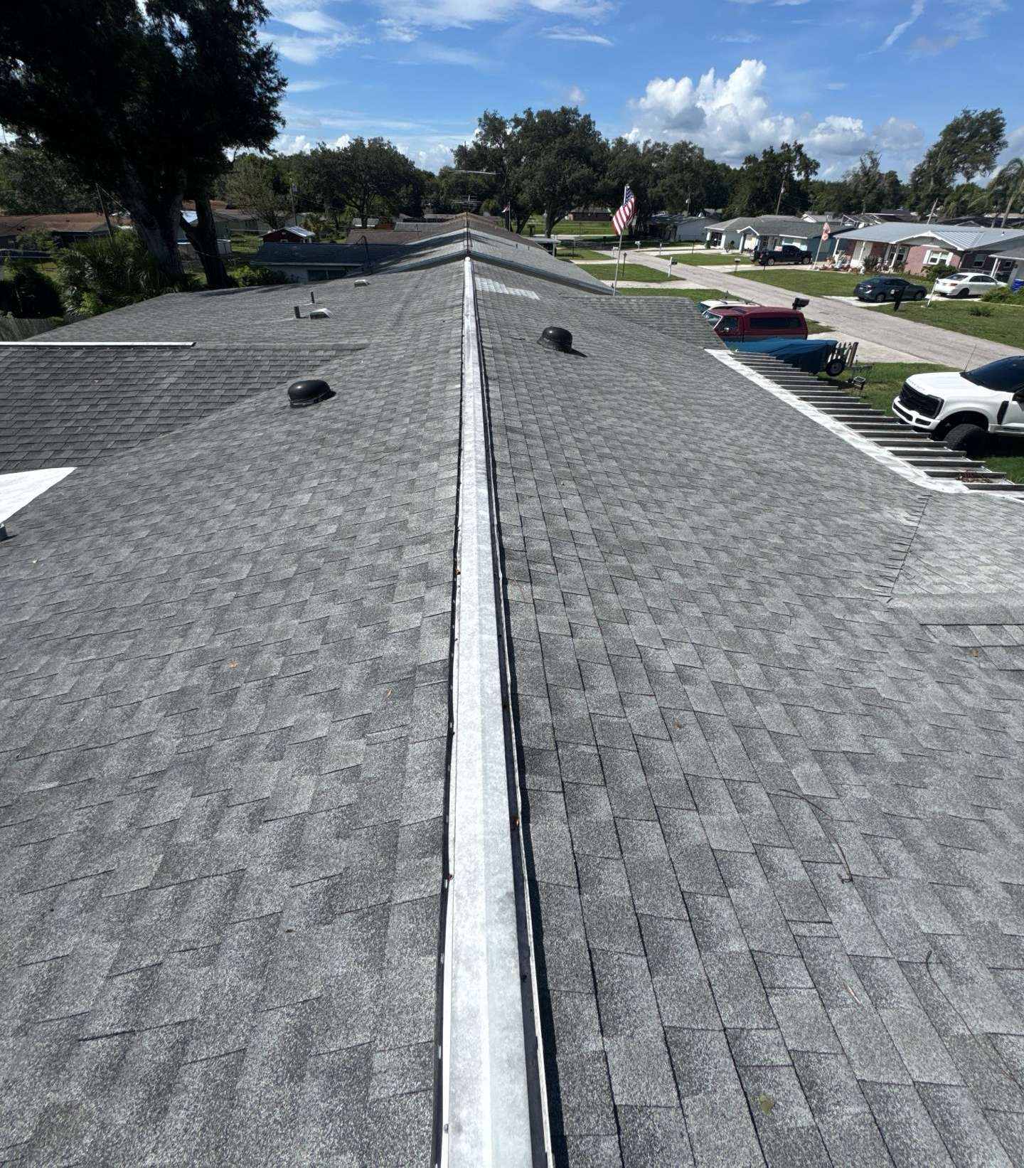Old gray shingle roof and worn ridge vent on a ranch home in Zephyrhills FL