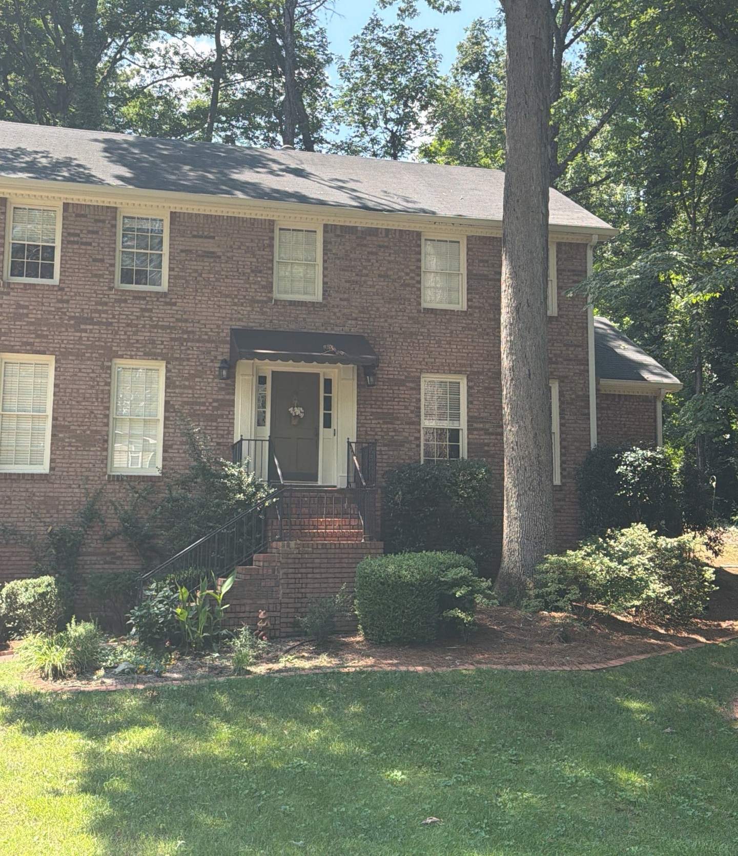 Front of a two-story brick colonial in Roswell GA before its shingle roof was replaced