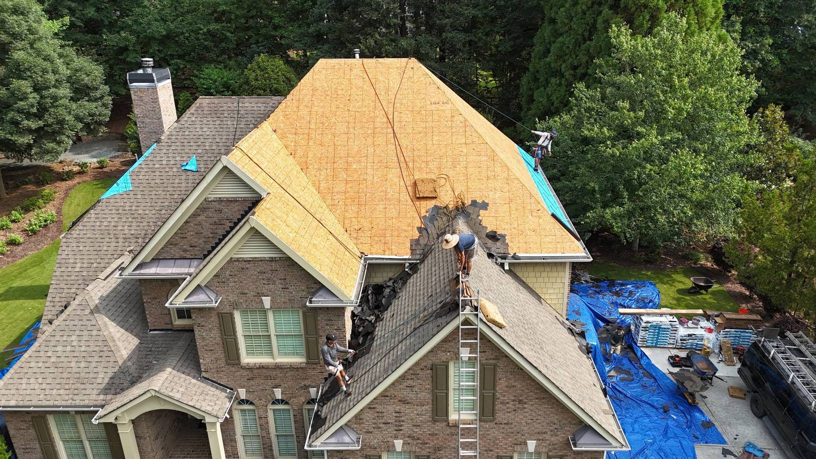 Crew removing old shingles down to the plywood deck on a Suwanee GA home