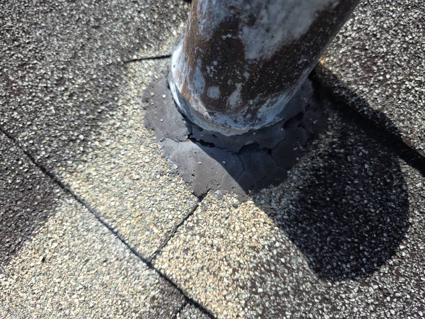 Rusting vent pipe with cracked mastic on the old roof in Port Orange FL