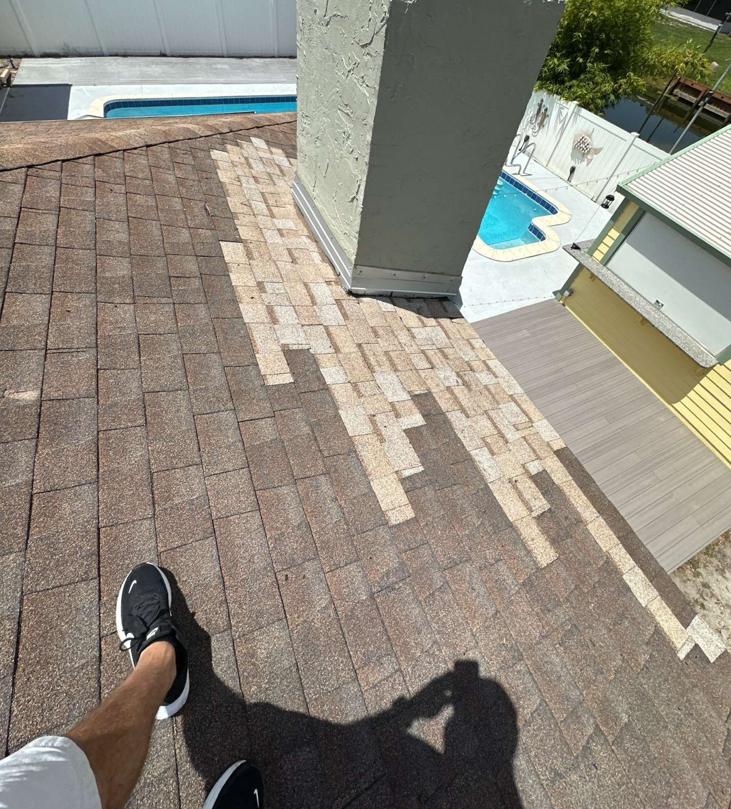 Patched shingles next to the chimney on the old roof in Lake Wales FL