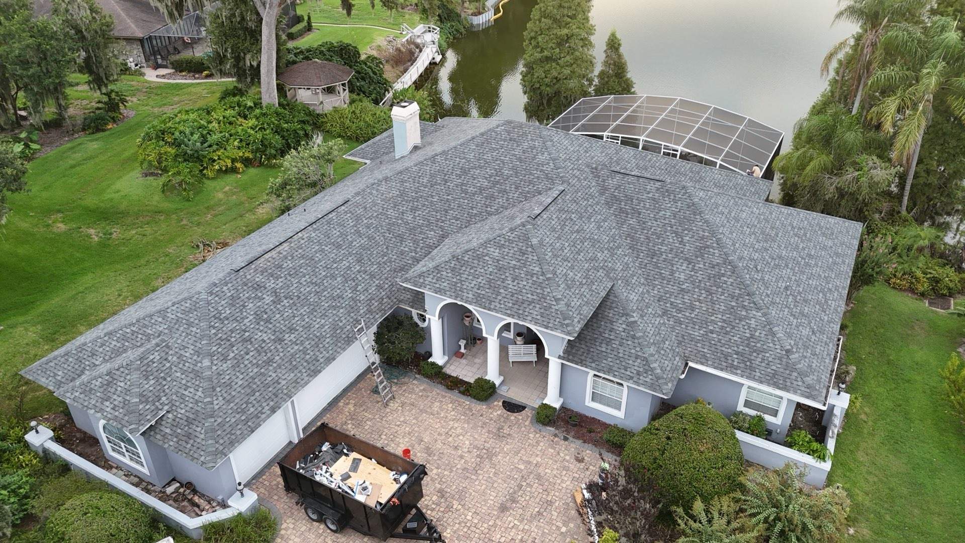 Aerial view of the finished shingle roof on the lakefront home in Lakeland FL